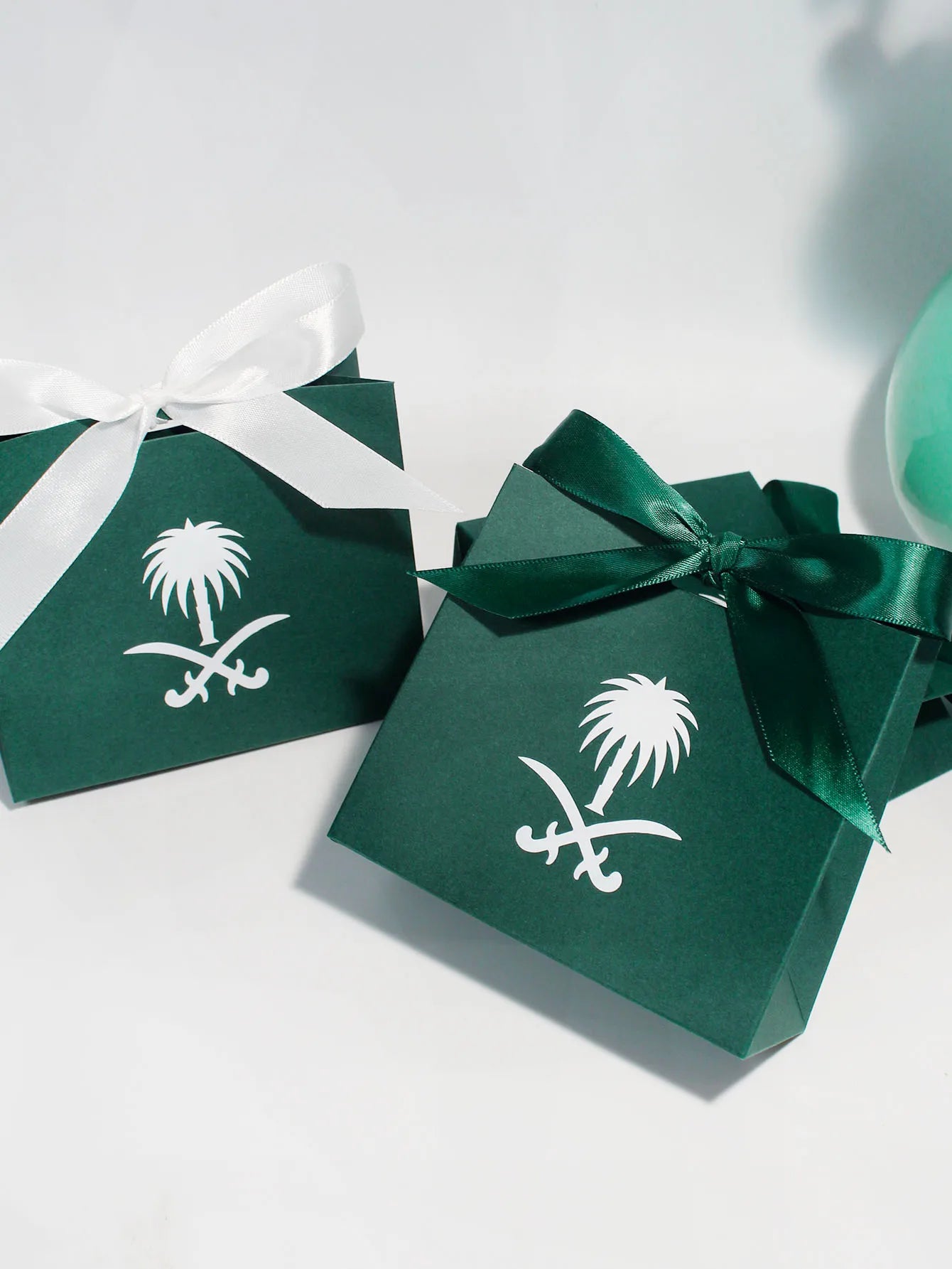 Green gift box with a palm tree design, perfect for celebrating Saudi National Day.